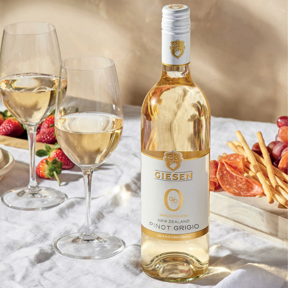 Giesen Pinot Grigio Poured into two glasses with cheeseboard