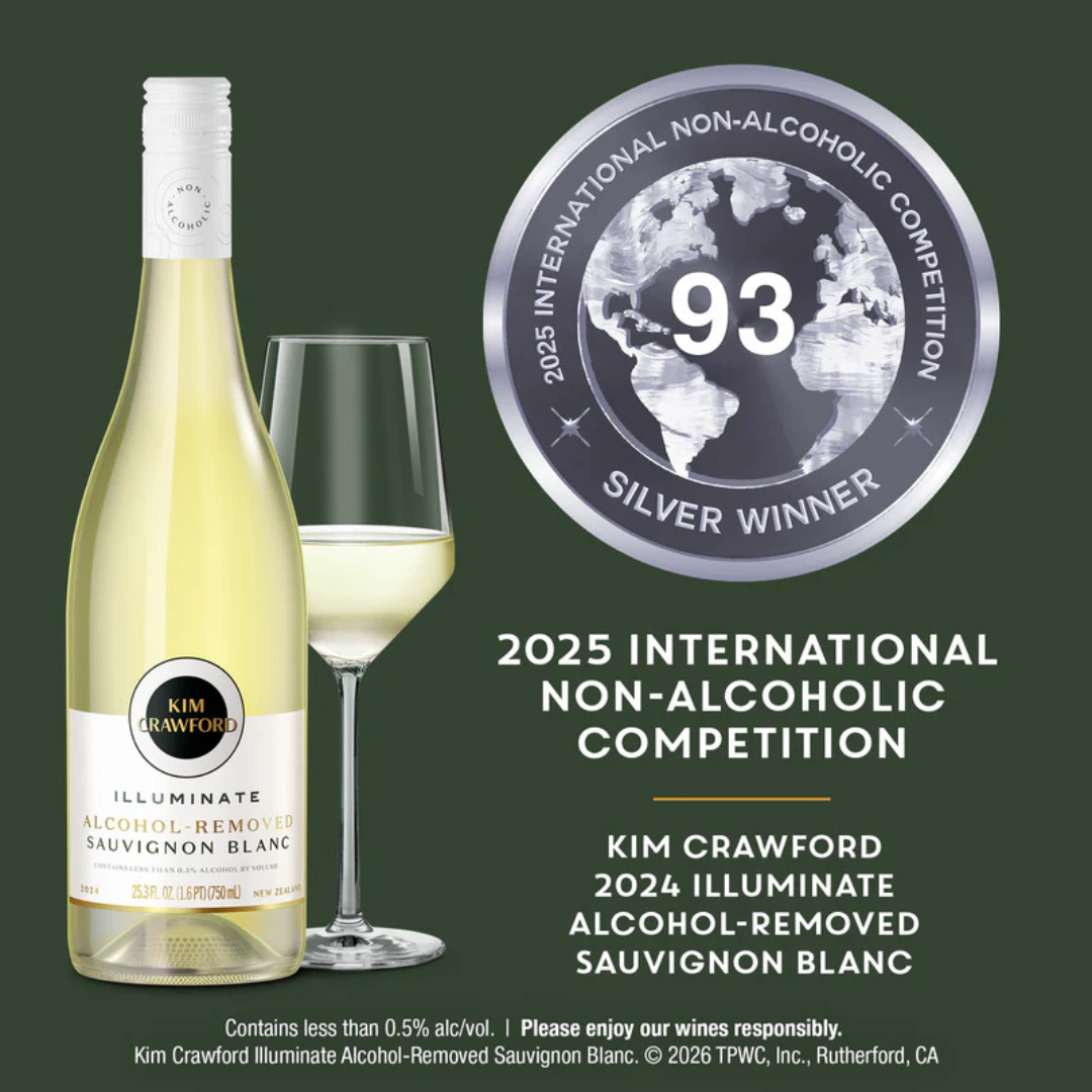Kim Crawford Illuminate Alcohol-Removed Sauvignon Blanc wine bottle shown beside a filled wine glass on a dark green background, with a silver 2025 International Non-Alcoholic Competition Silver Winner seal and product text.