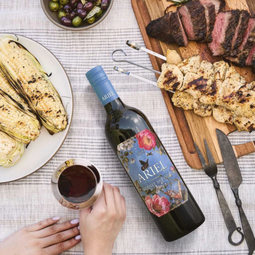 Ariel Cabernet Sauvignon poured in a glass with steak, barbeque.